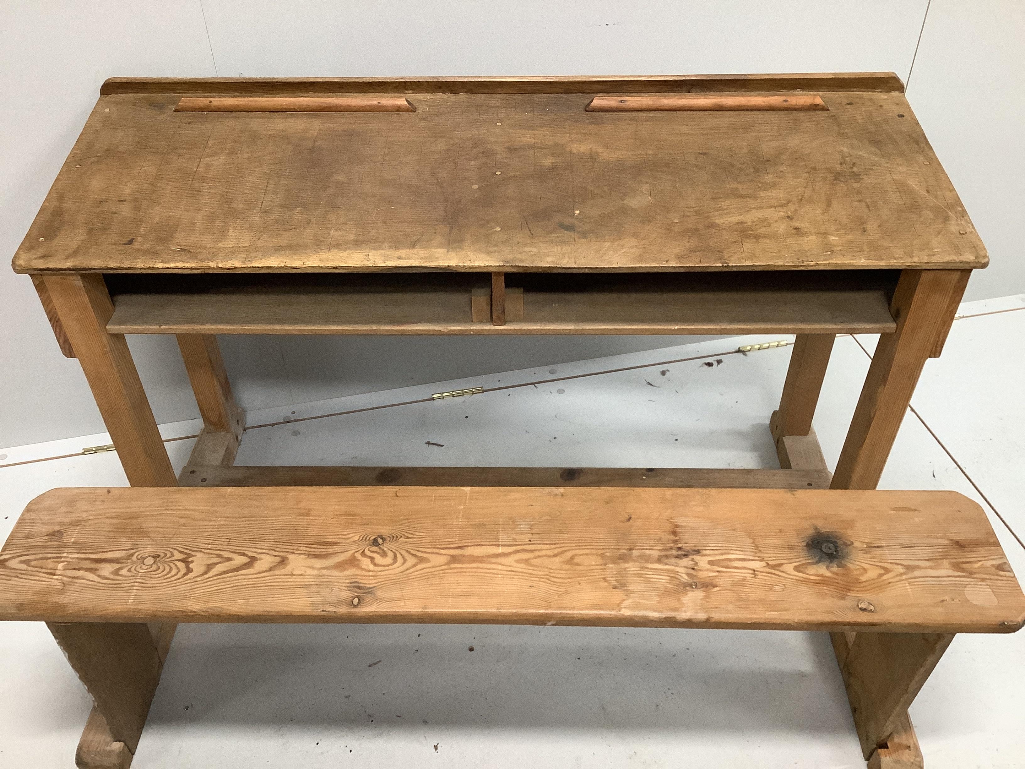 An early 20th century oak and pine child's desk with integral seat, width 120cm, depth 70cm, height 72cm